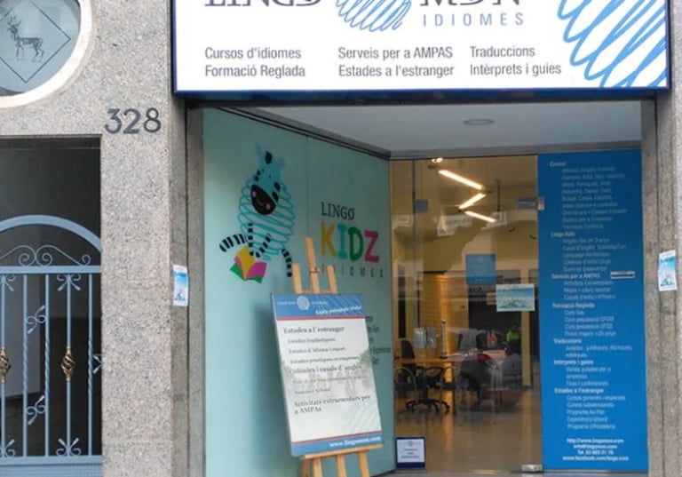 Storefront for Lingo Idiomes language school at address 328, with blue signage and glass entrance displaying KIDZ program information